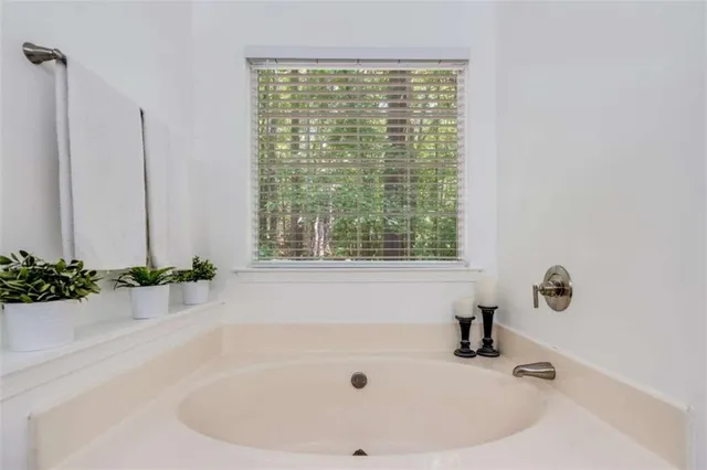 a white bath tub sitting in a bathroom next to a window