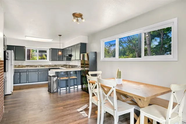 a kitchen with a table chairs a sink dishwasher window and cabinets