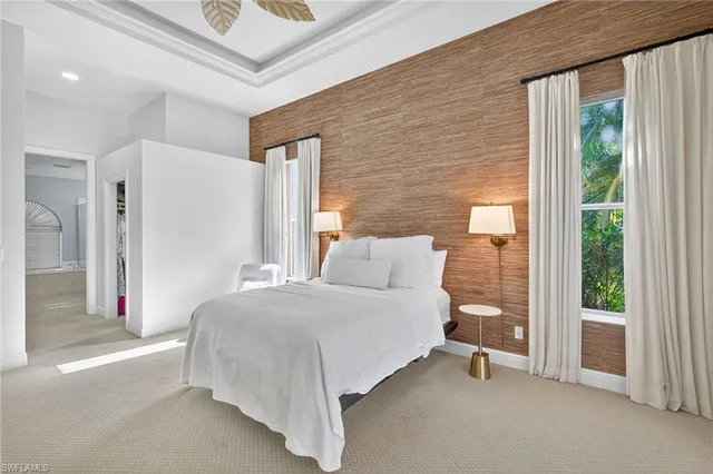 a bedroom with a bed and a large window