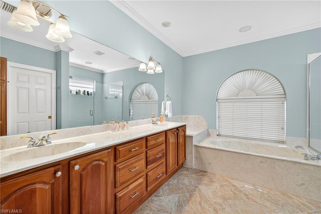 2229 Goshawk Court Naples, FL 34105 - Photo 12 of 26 a spacious bathroom with a double vanity sink mirror and bathtub
