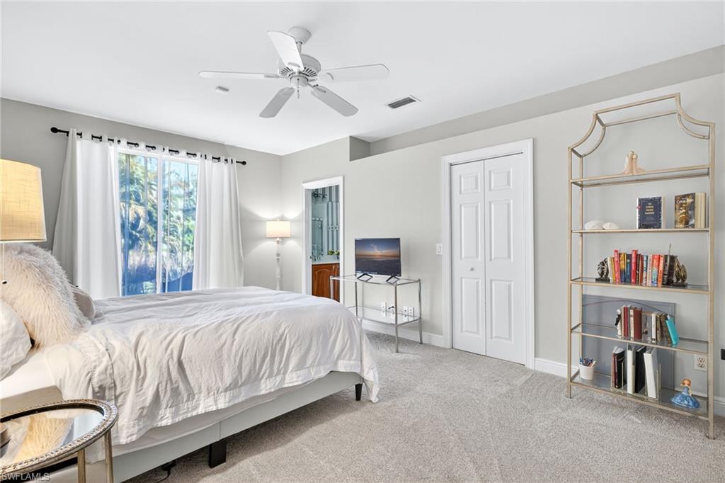 2229 Goshawk Court Naples, FL 34105 - Photo 13 of 26 a bedroom with a large bed and a chandelier