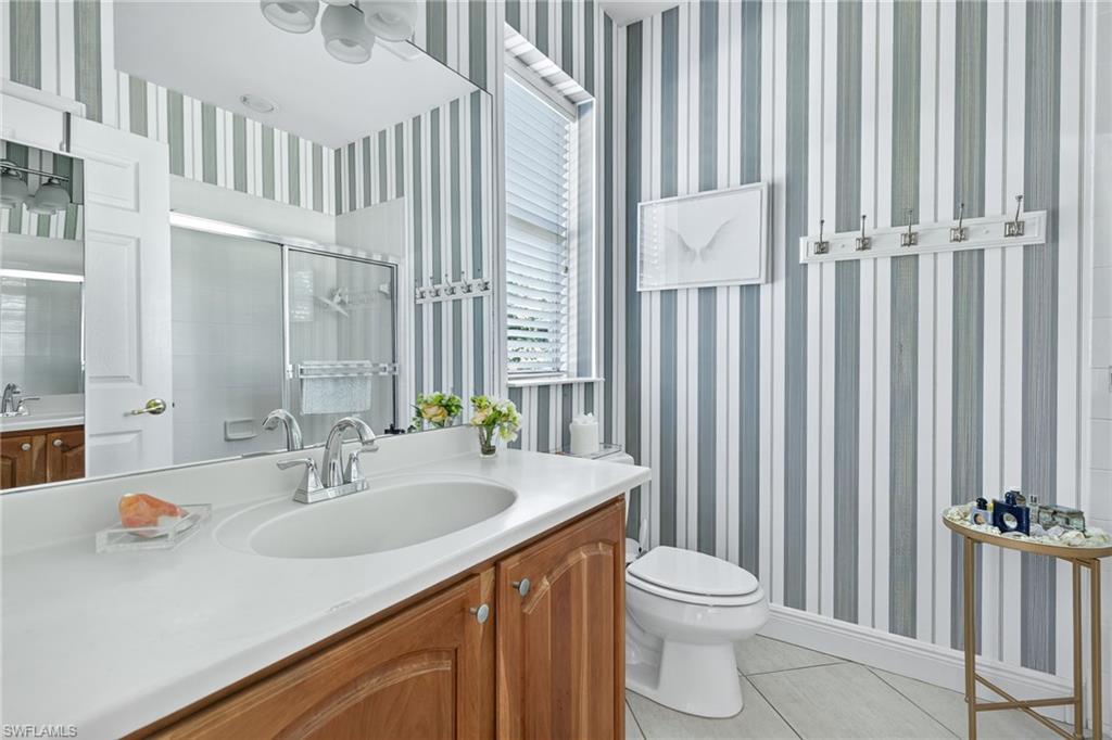 2229 Goshawk Court Naples, FL 34105 - Photo 14 of 26 a bathroom with a sink a toilet and shower curtain