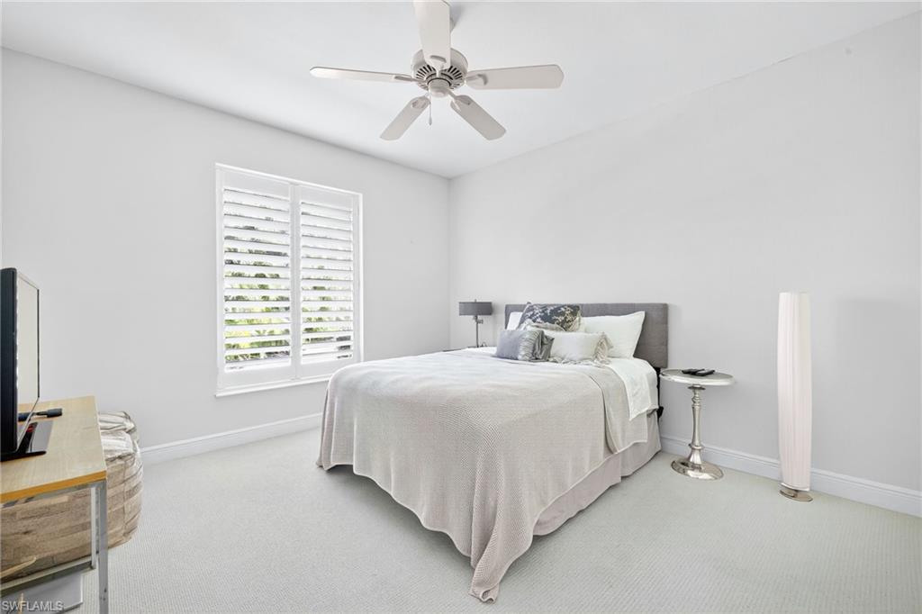 2229 Goshawk Court Naples, FL 34105 - Photo 15 of 26 a bedroom with a bed and a flat tv screen on the dresser