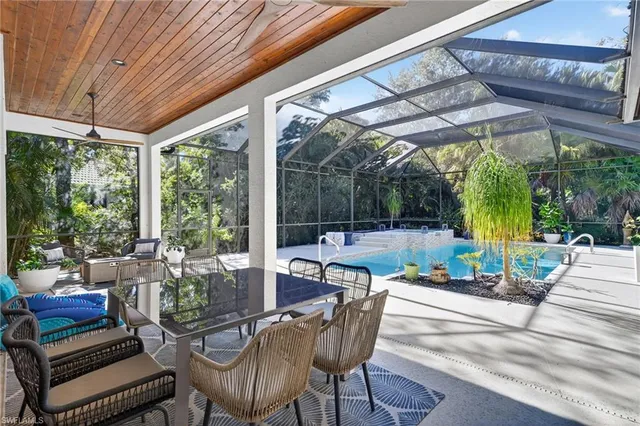 a view of patio with table and chairs potted plants and large tree