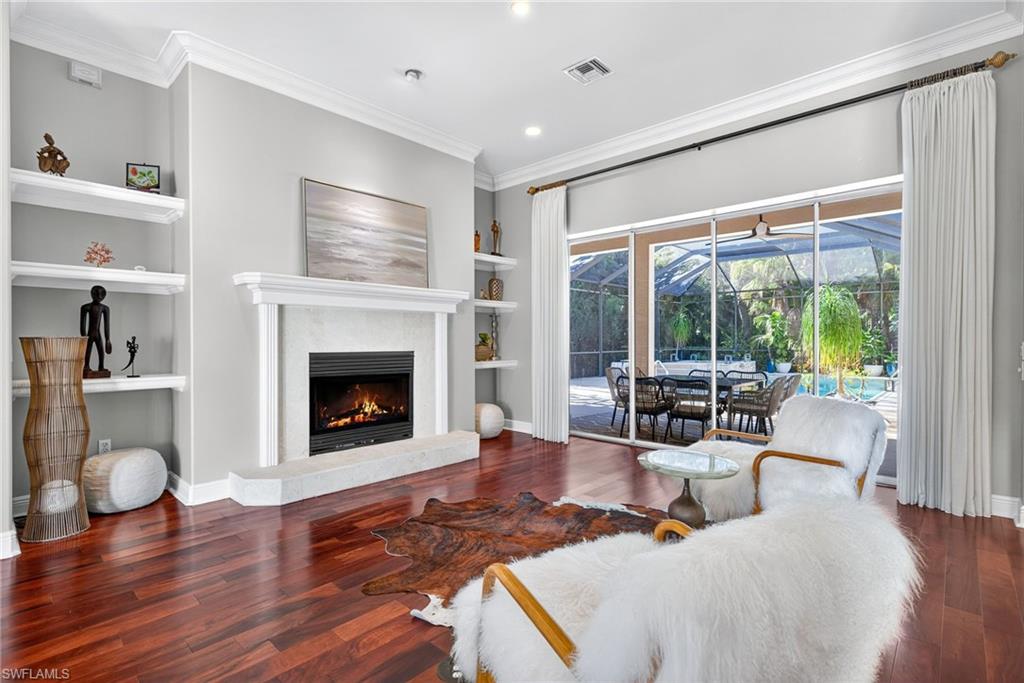 2229 Goshawk Court Naples, FL 34105 - Photo 2 of 26 a living room with furniture a fireplace and a large window