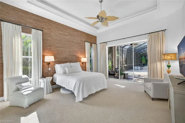 a spacious bedroom with a large bed couch and a large window