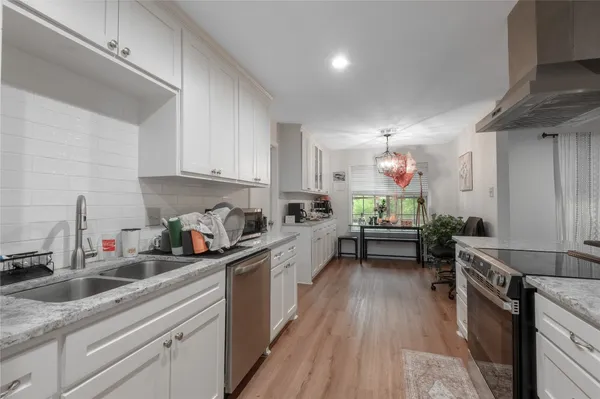 a kitchen with kitchen island granite countertop lots of counter top space a sink and appliances