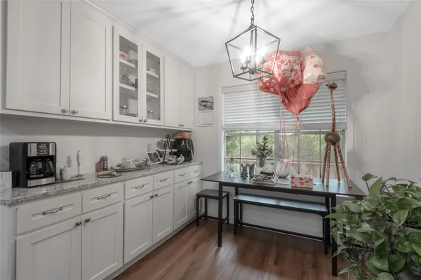 a kitchen with stainless steel appliances granite countertop a sink dishwasher and white cabinets with wooden floor