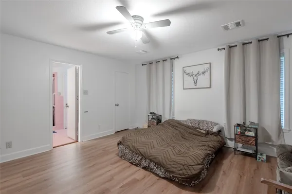 a spacious bedroom with a bed and a chandelier