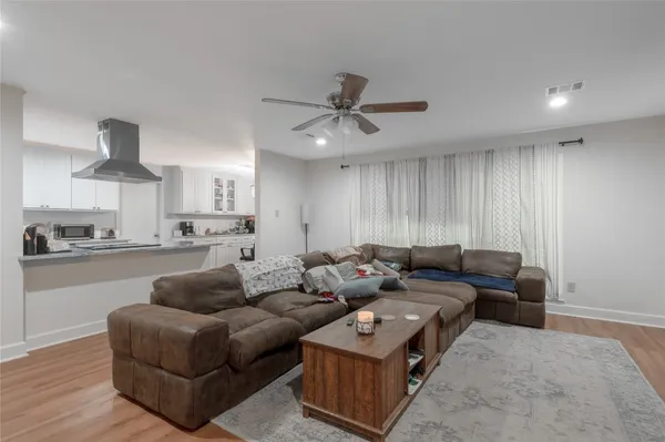 a living room with furniture and a view of kitchen