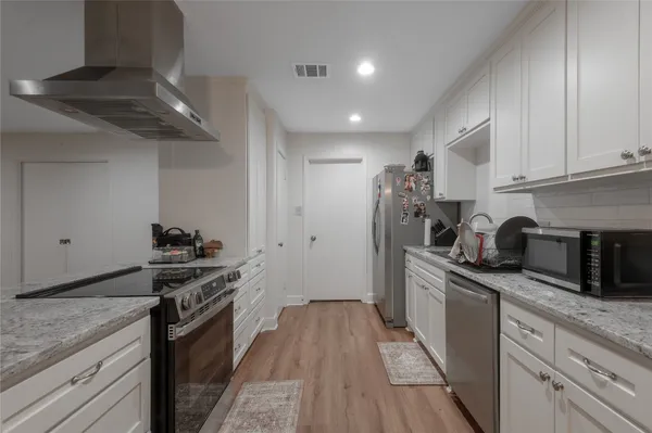 a kitchen with stainless steel appliances granite countertop a stove sink and cabinets