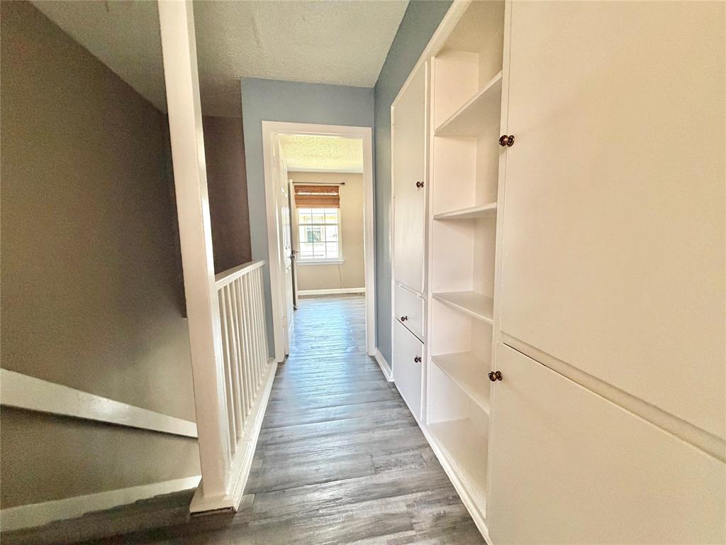 8001 Rothington Road, Unit 3137 Dallas, TX 75227 - Photo 17 of 21 Hallway featuring integrated built-in cabinetry with both enclosed storage and open shelving