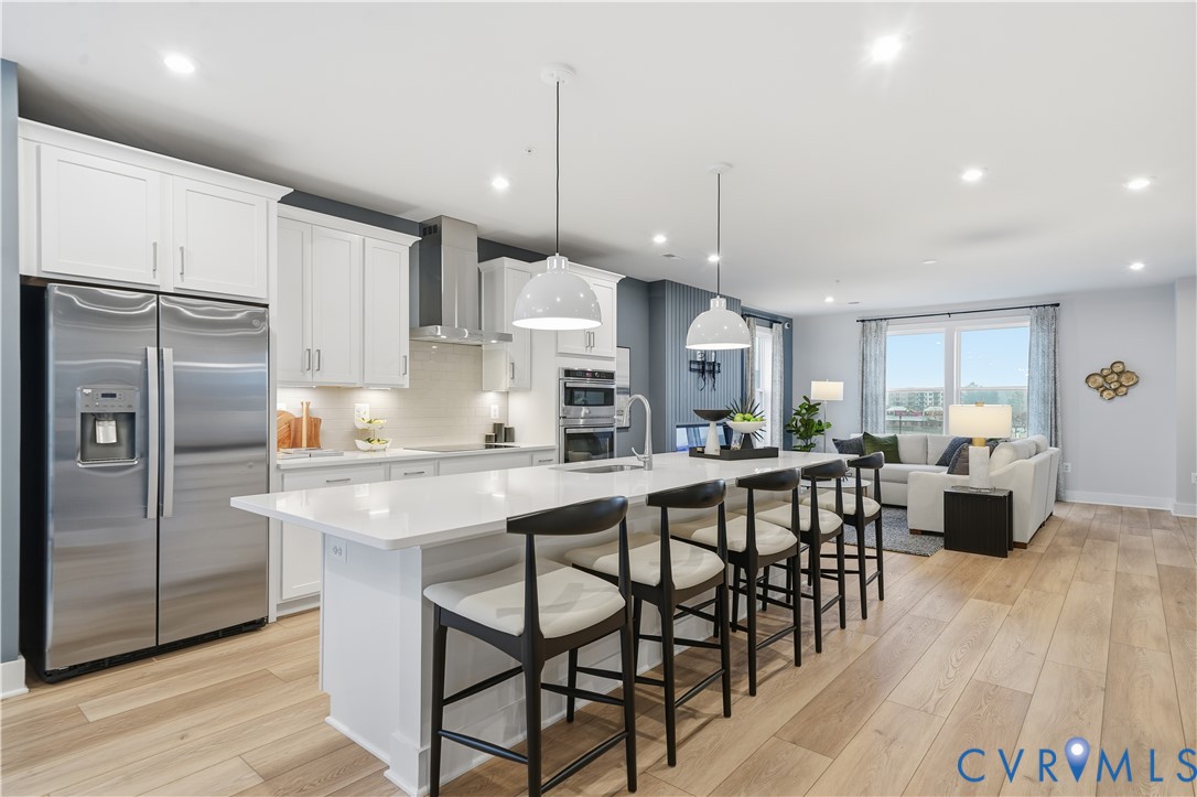 9881 Tuco Street, Unit B Glen Allen, VA 23059 - Photo 14 of 50 a kitchen with stainless steel appliances kitchen island granite countertop a table chairs and a refrigerator