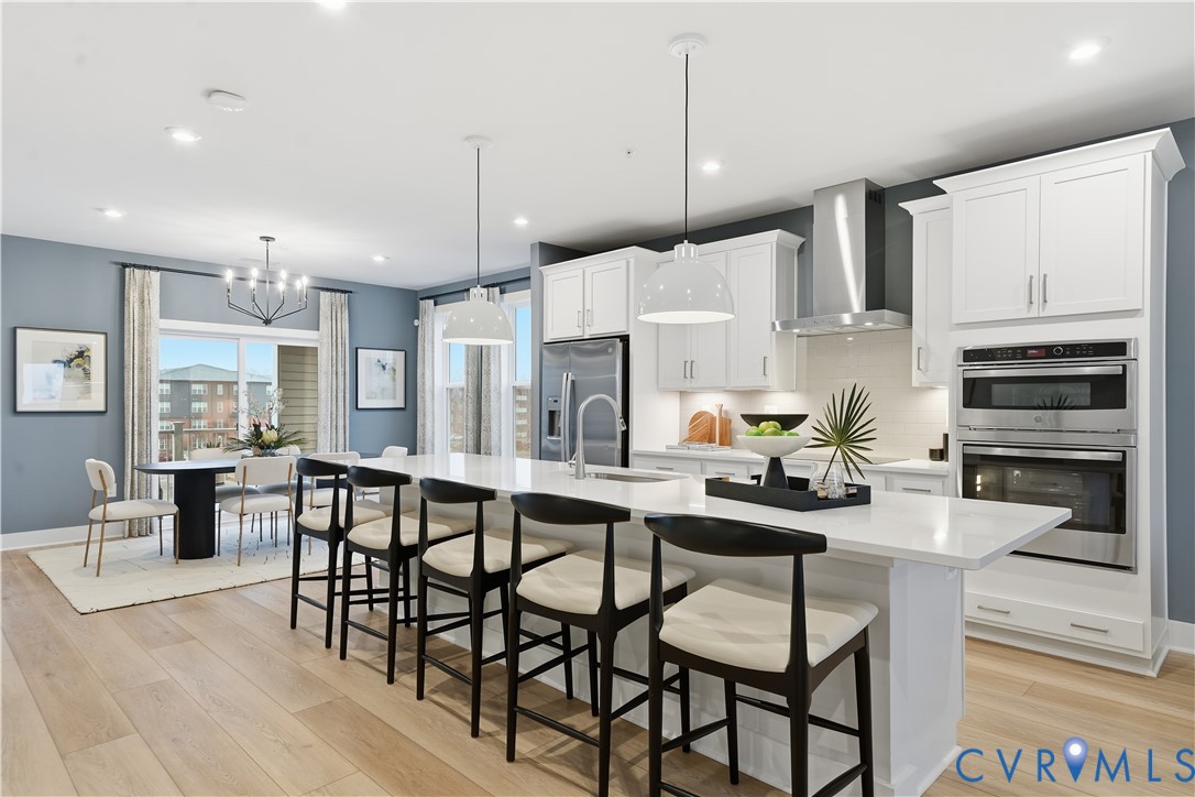 9881 Tuco Street, Unit B Glen Allen, VA 23059 - Photo 15 of 50 a kitchen with stainless steel appliances kitchen island granite countertop a dining table chairs and white cabinets