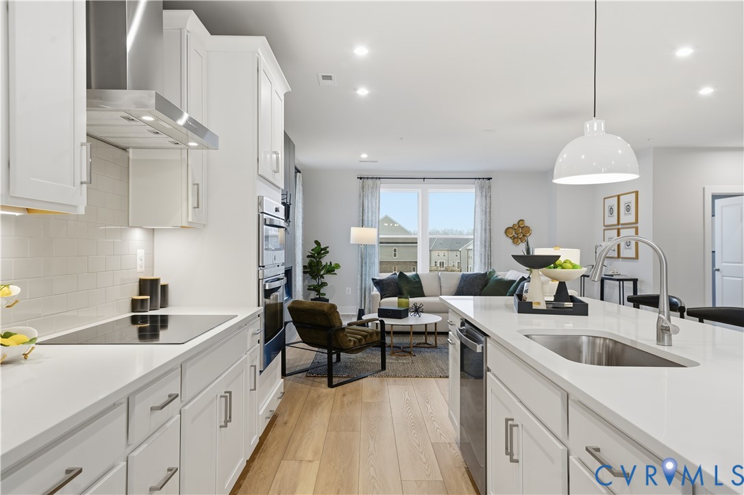 9881 Tuco Street, Unit B Glen Allen, VA 23059 - Photo 18 of 50 a kitchen with stainless steel appliances a sink a stove and a wooden floors
