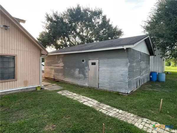 a view of backyard of house with wooden fence