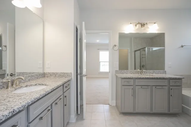 a bathroom with a granite countertop sink a large mirror and a shower