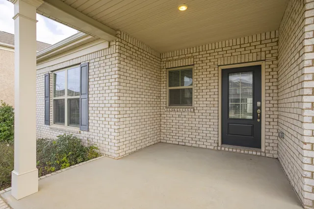 a view of a brick house next to a yard