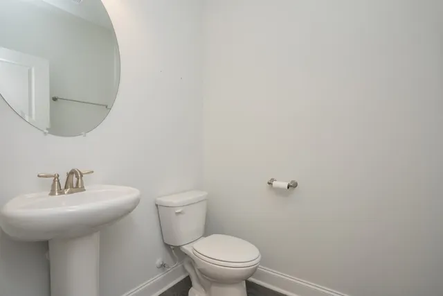 a bathroom with a toilet a sink and mirror