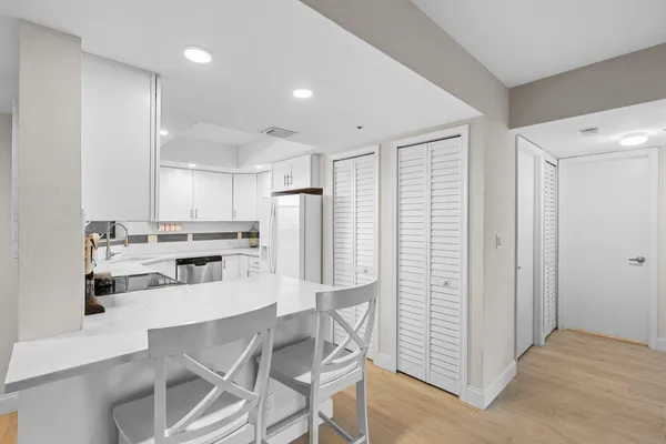 a kitchen with stainless steel appliances kitchen island granite countertop a refrigerator and cabinets