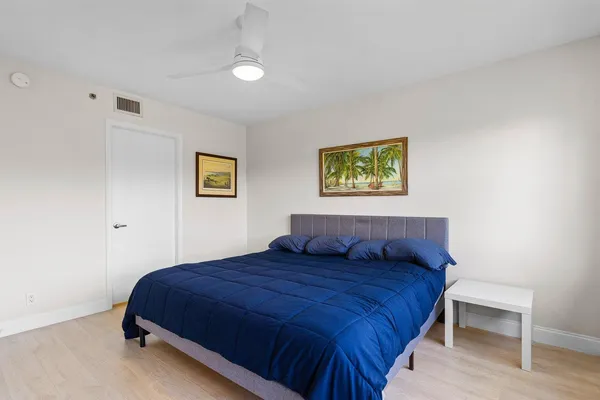 a bedroom with a large bed and a painting on the wall