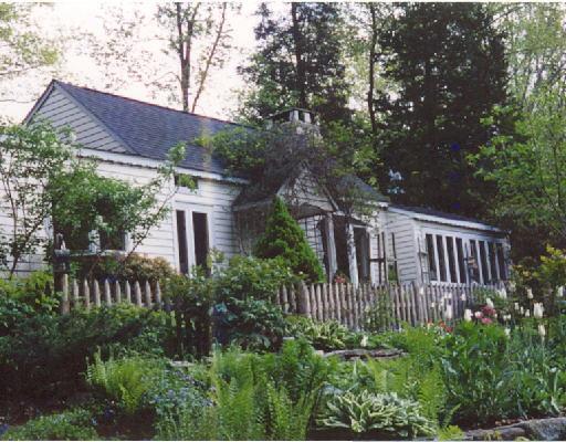 a view of a house with brick walls and flower plants