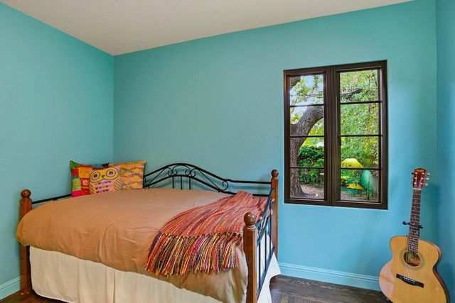 a bed sitting in a bedroom next to a window