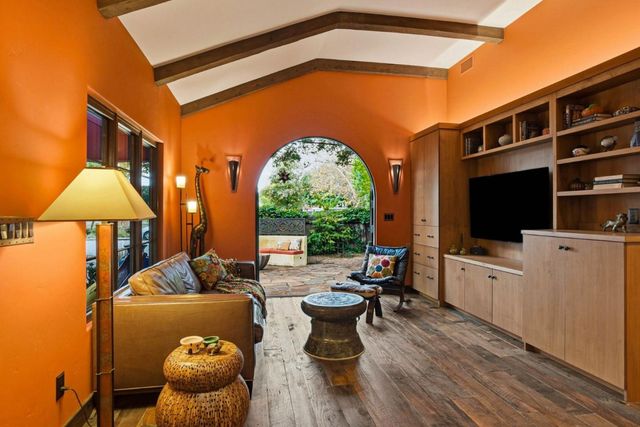 a living room with furniture a flat screen tv and floor to ceiling window