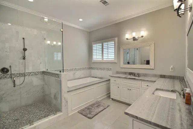 a bathroom with a granite countertop sink a toilet a mirror and window