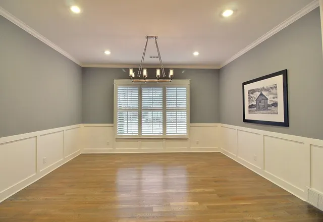 a view of an empty room with a window and chandelier