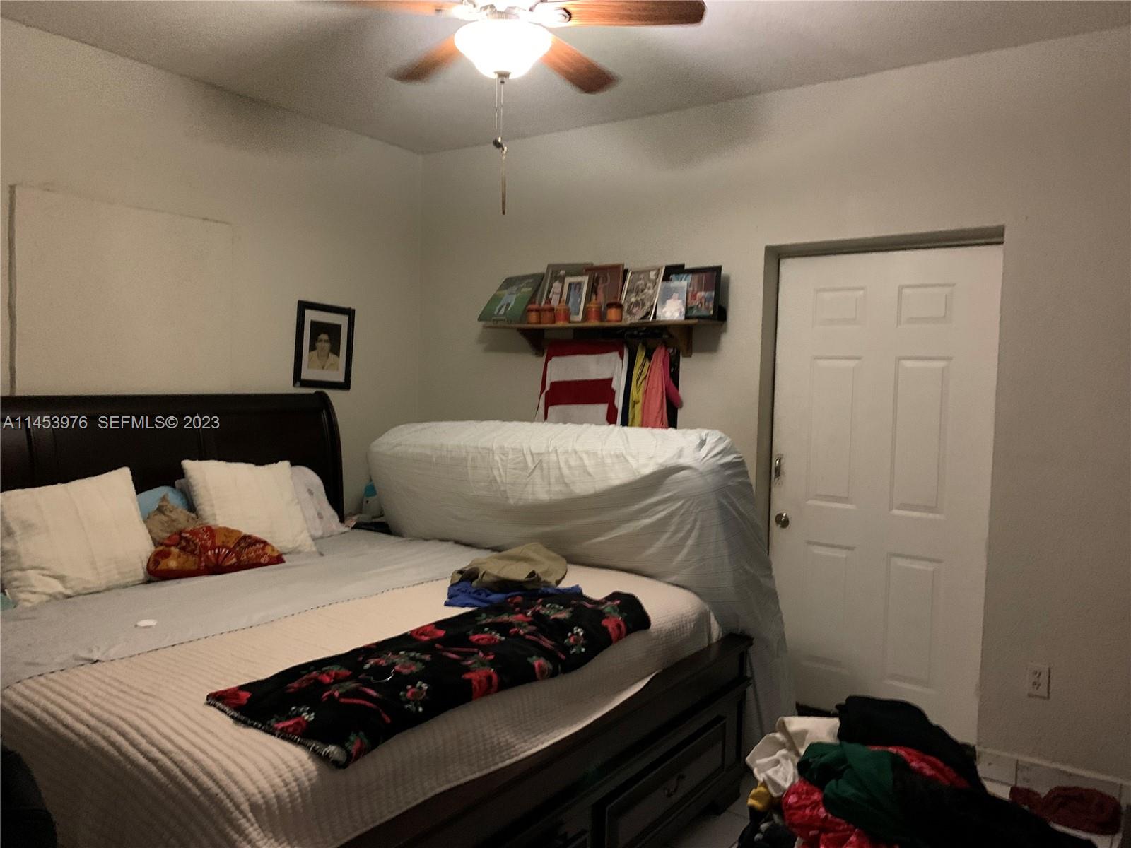 1104 Northwest 6 Street Miami, FL 33136 - Photo 9 of 16 a bedroom with bed and a chandelier