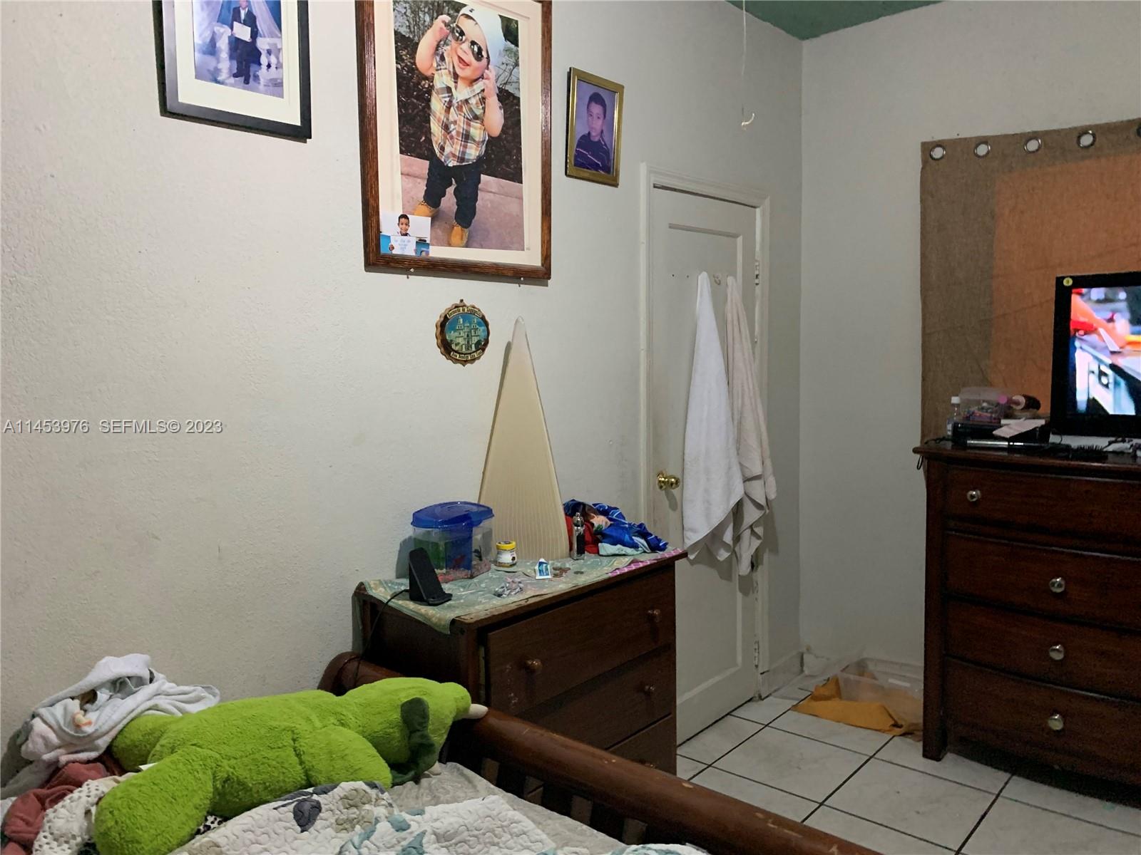 1104 Northwest 6 Street Miami, FL 33136 - Photo 10 of 16 a bedroom with a bed and wooden floor