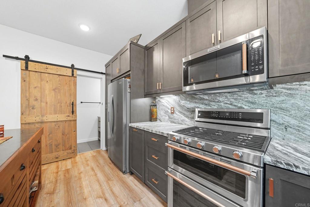 122 Diamante Road San Marcos, CA 92078 - Photo 5 of 36 a kitchen with stainless steel appliances granite countertop a stove microwave and refrigerator