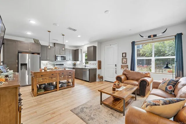 a living room with furniture kitchen and a large window