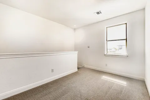 an empty room with wooden floor cabinet and a ceiling fan