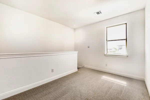 an empty room with wooden floor cabinet and a ceiling fan