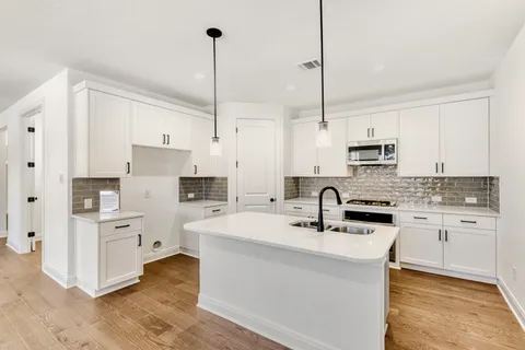 a kitchen with kitchen island white cabinets sink and white appliances