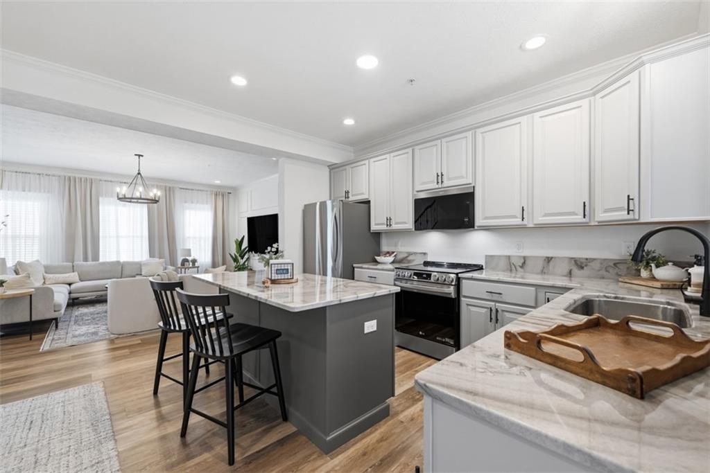 139 Rylie Drive Harmony, PA 16037 - Photo 9 of 46 a kitchen with stainless steel appliances granite countertop a stove top oven a sink a stove a dining table and chairs