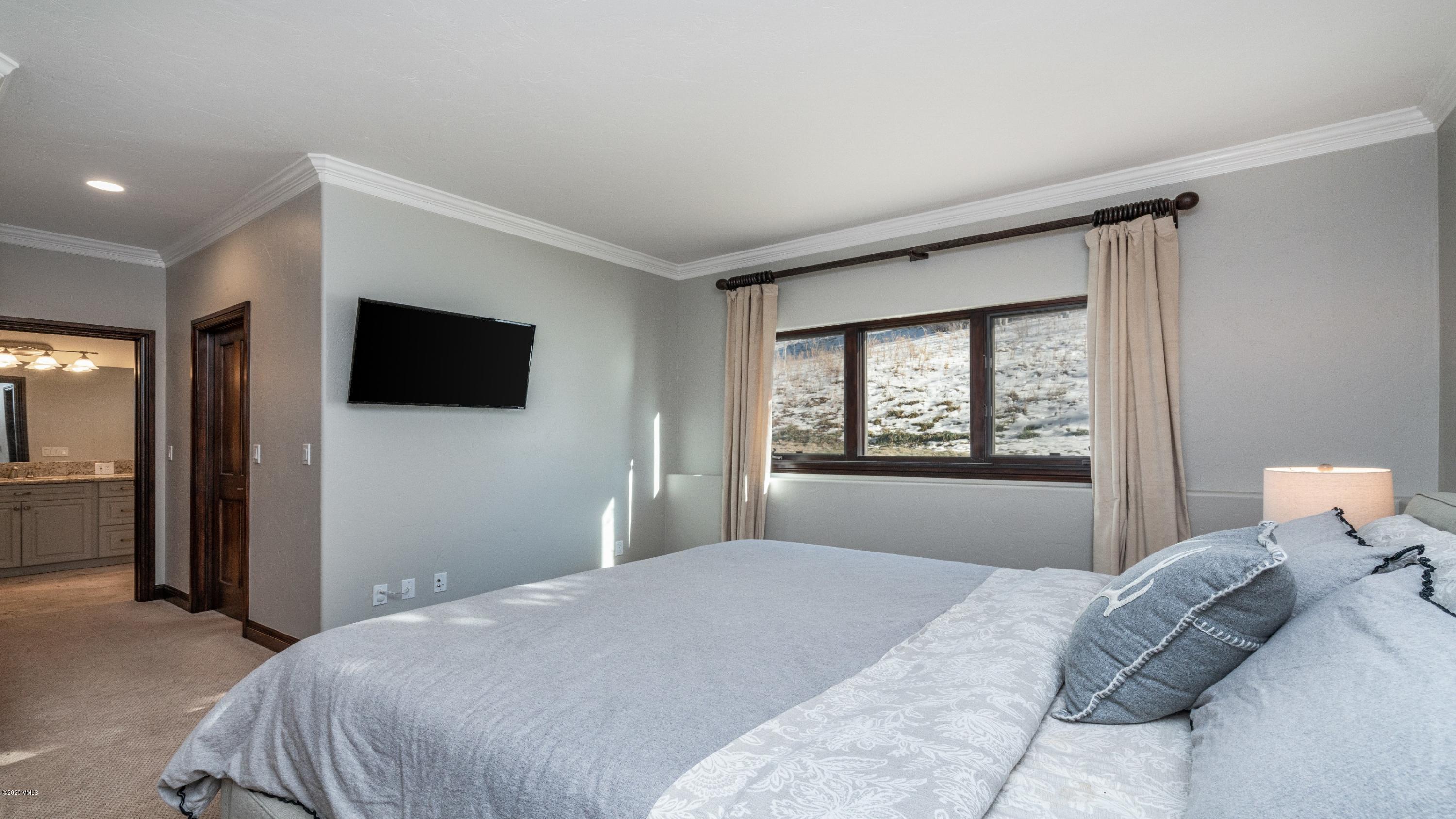 52 Andover Trail Edwards, CO 81632 - Photo 22 of 33 a bedroom with a large bed and a flat screen tv