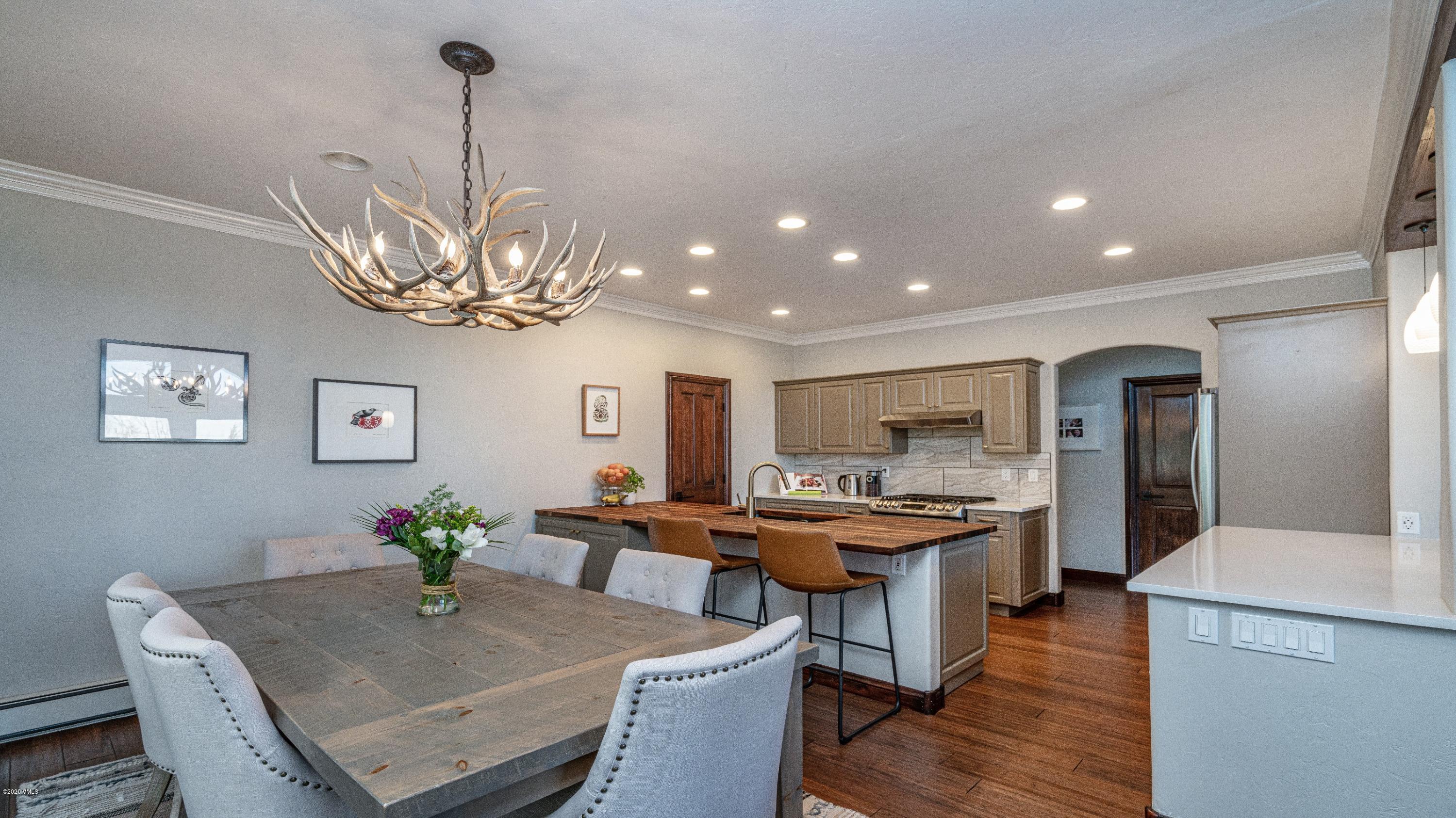 52 Andover Trail Edwards, CO 81632 - Photo 7 of 33 a kitchen with stainless steel appliances kitchen island granite countertop a table chairs in it and wooden floors
