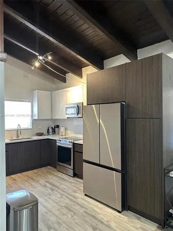 a kitchen with stainless steel appliances a refrigerator and a stove top oven