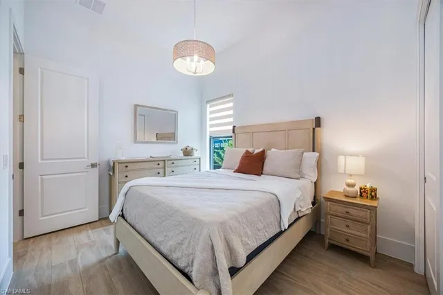 a bedroom with bed and wooden floor