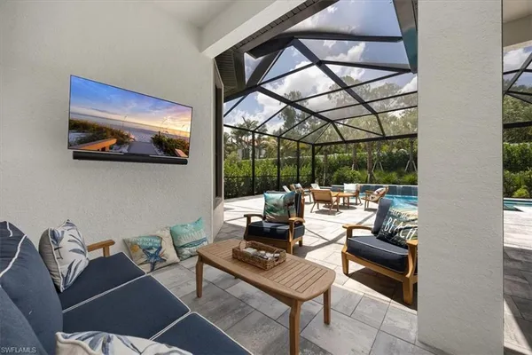 a living room with furniture a floor to ceiling window and a flat screen tv