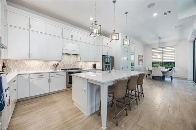 a kitchen with a white cabinets and chairs in it