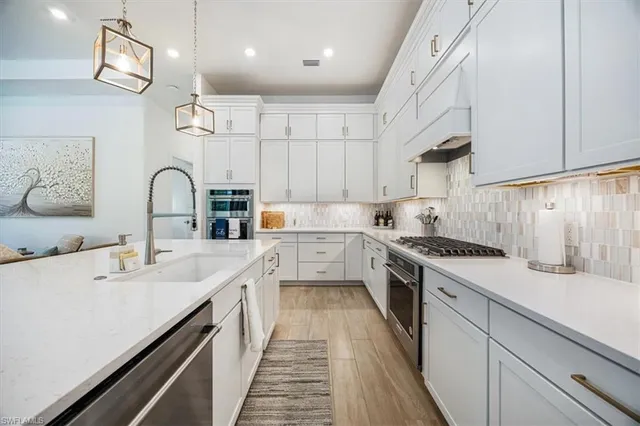 a kitchen with a sink stove and white cabinets