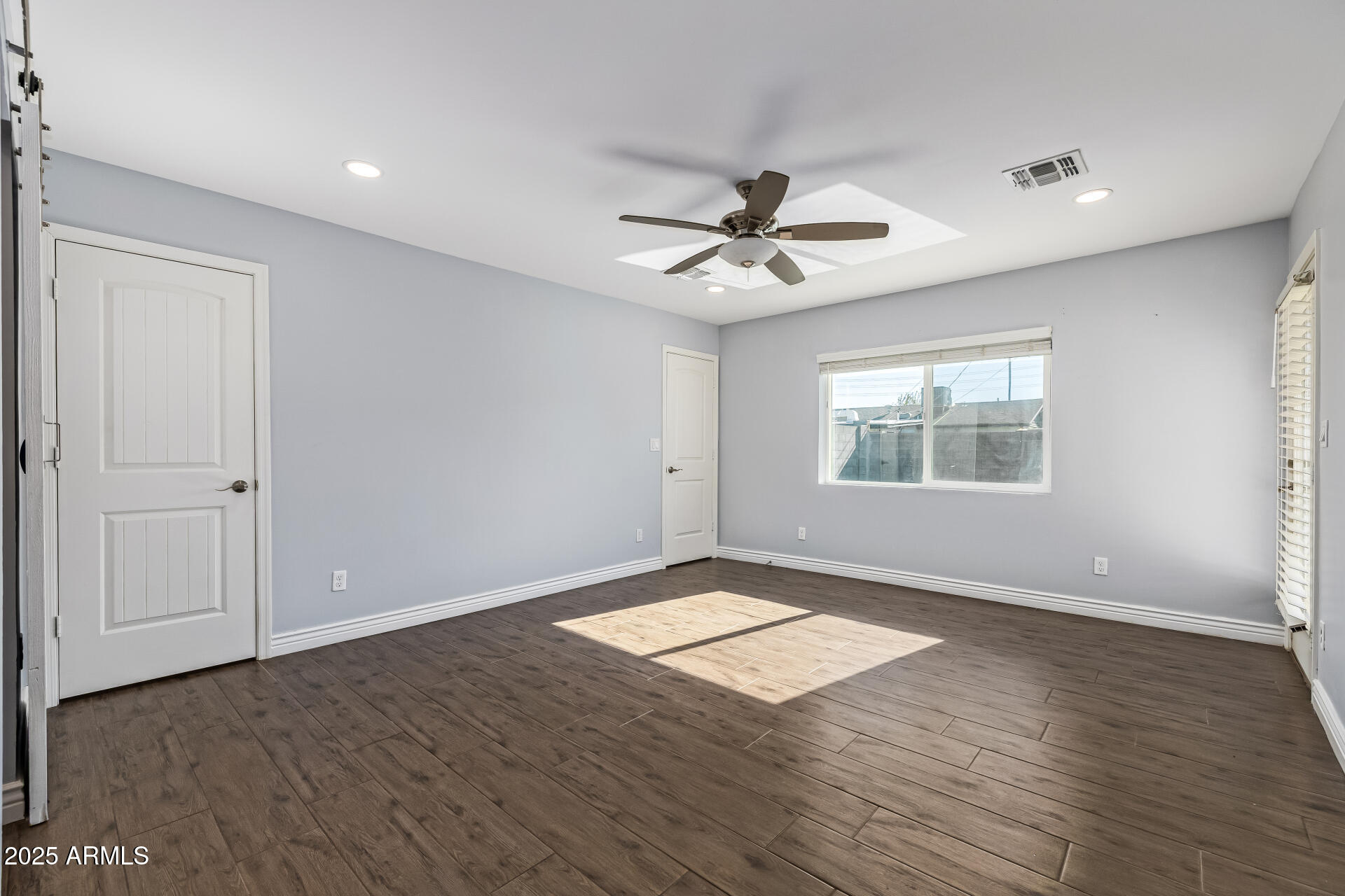 2439 East Minnezona Avenue Phoenix, AZ 85016 - Photo 11 of 25 an empty room with wooden floor chandelier and windows