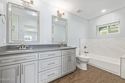 a bathroom with a granite countertop toilet a sink and a bathtub