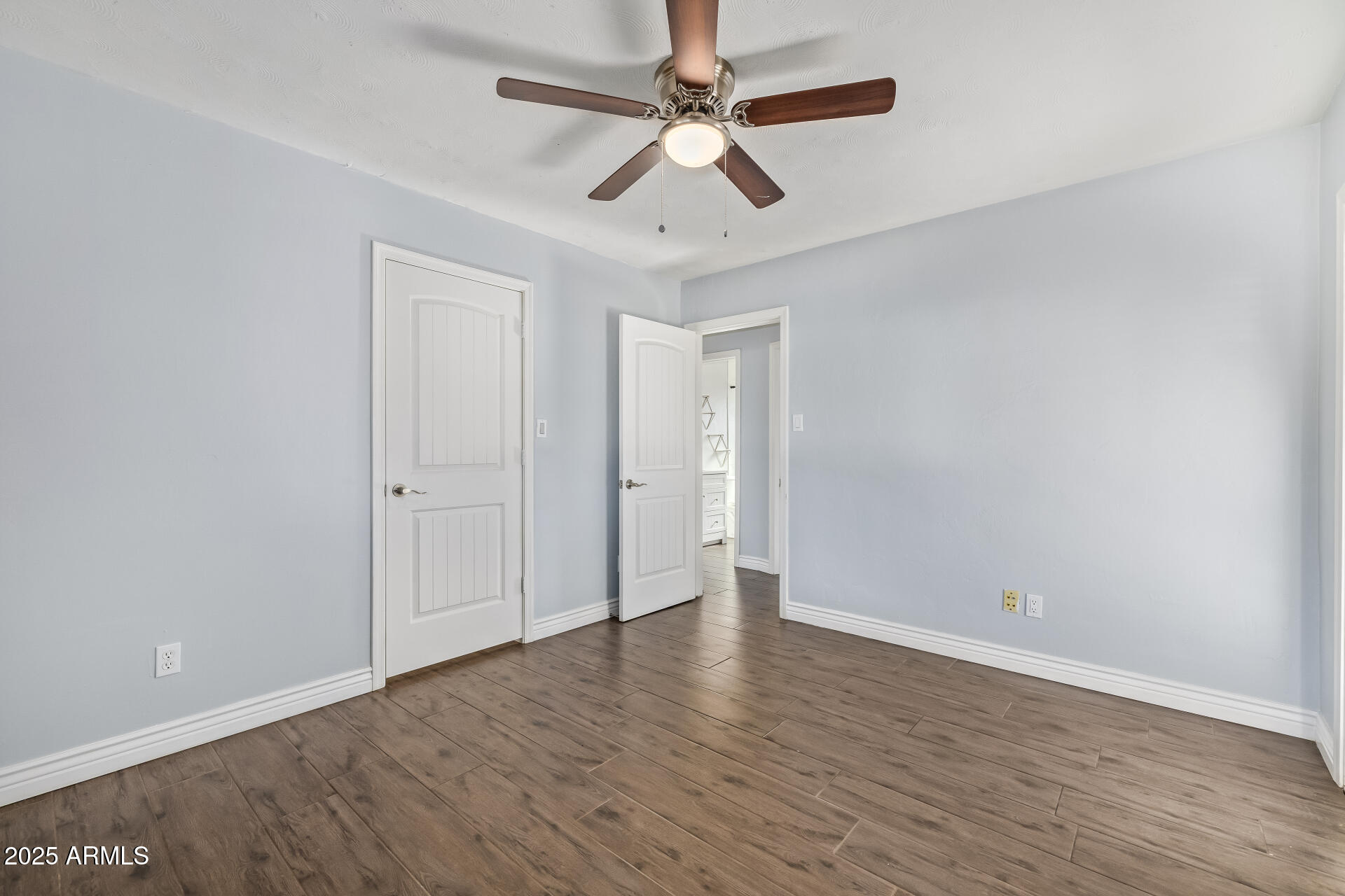 2439 East Minnezona Avenue Phoenix, AZ 85016 - Photo 17 of 25 a view of an empty room with window a ceiling fan and wooden floor