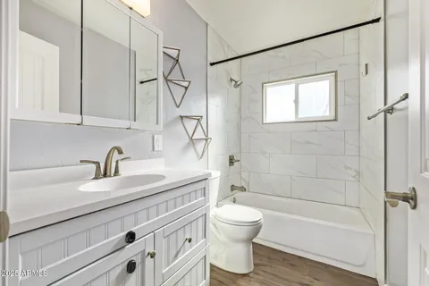 a bathroom with a granite countertop sink a toilet and shower