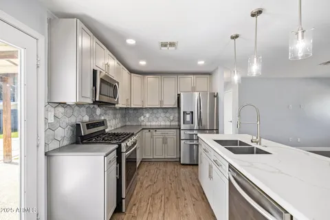 a kitchen with a sink a counter space stainless steel appliances and cabinets